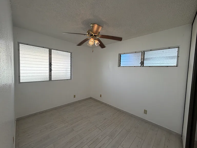Bedroom 2, corner with ceiling fan, cross ventilation windows