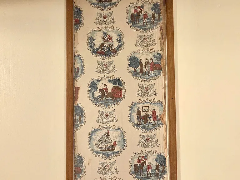 A small preserved section of original wallpaper is featured among reclaimed chestnut and walnut which proudly represents this property's colonial heritage.
