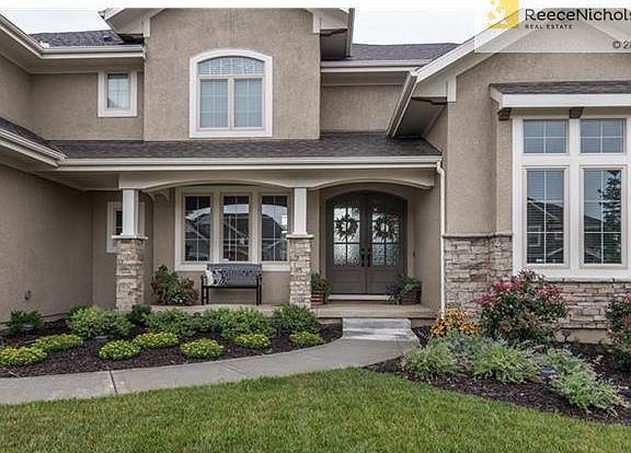 Beautiful landscaping showcases double front entry doors.