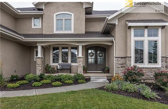 Beautiful landscaping showcases double front entry doors.
