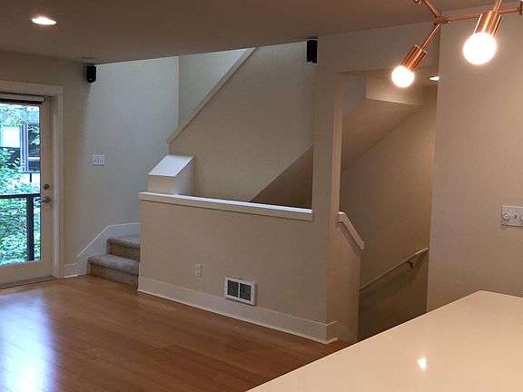 View from kitchen island through living, stairs, deck door
