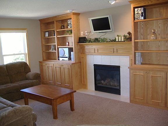 Comfortable family room has custom build-ins framing a gas fireplace and featu