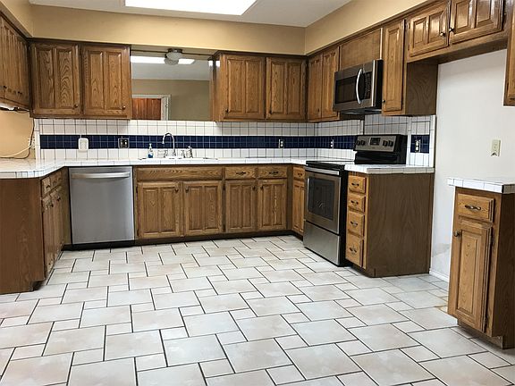 Spacious tiled kitchen has new stove, microwave and dishwasher.
