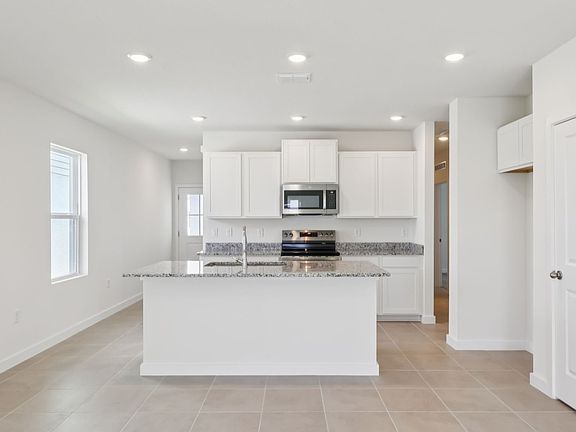 Bright Kitchen with granite Countertops, an Island with dishwasher and ample cabinetry and spacious