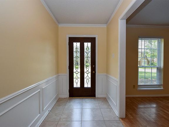 Enter through the glass and wood front door into an over sized foyer featuring crown molding, 18" tile flooring and coat closet.