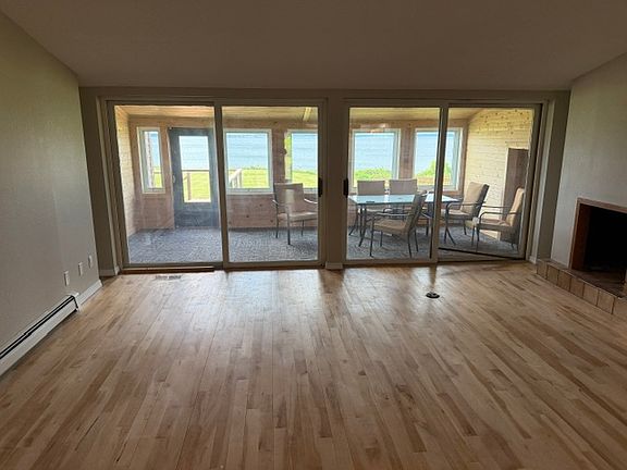 View of 4 season porch from living room. Lake Superior seen through windows of the porch and access to large outdoor deck.