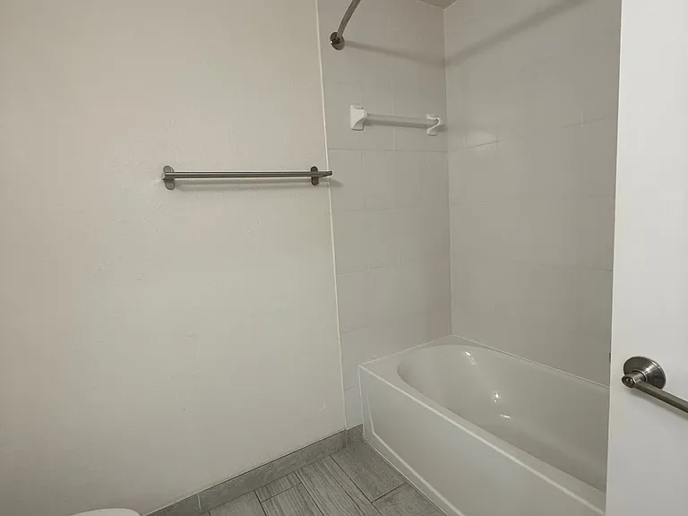Master bathroom includes a full shower and tub combo with modern tile flooring.