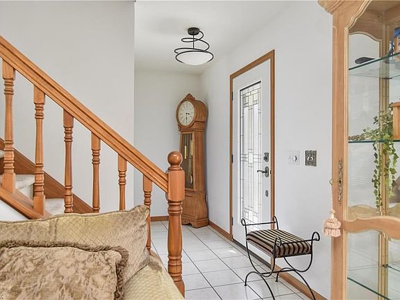 The foyer leads you into the formal living room on the right and into the open kitchen/living area to the right.
