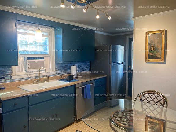 Kitchen features stainless stove, dishwasher, and refrigerator.