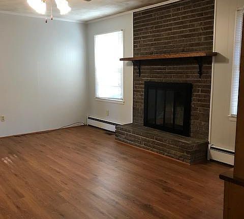 Family room with hardwood floors and wood burning fireplace.