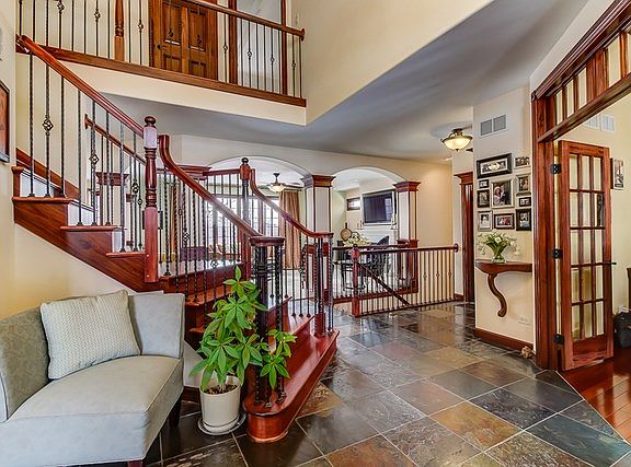 Two story entrance foyer, slate tile and custom staircase.