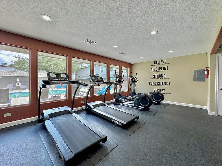 Stay active in a bright, modern fitness center featuring treadmills and natural light.