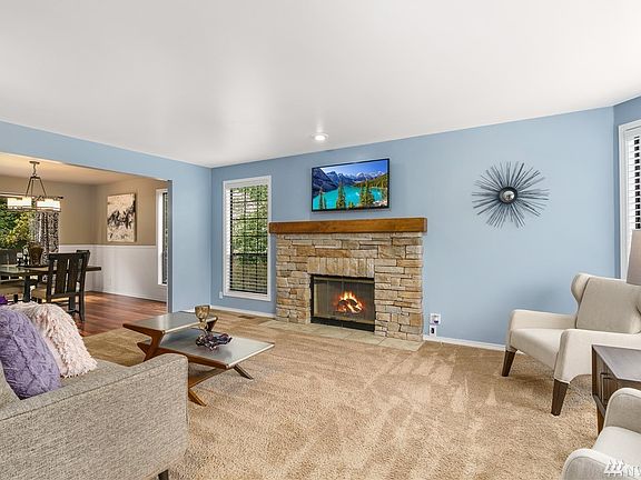 Formal living room with stone-wrapped wood-burning fireplace.
