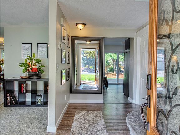 Updates include newer carpet and flooring throughout. From the entry your formal living room is to the left. Coat closet is on the right of this picture, behind the door.  Stairs leading to all three bedrooms and 2 full baths are also to the right. Main floor half bath is just beyond the stairs to the right.>