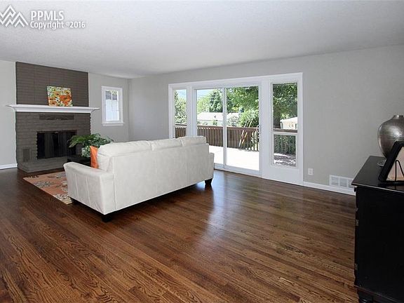 Living room with wood burning fireplace and new hardwood flooring