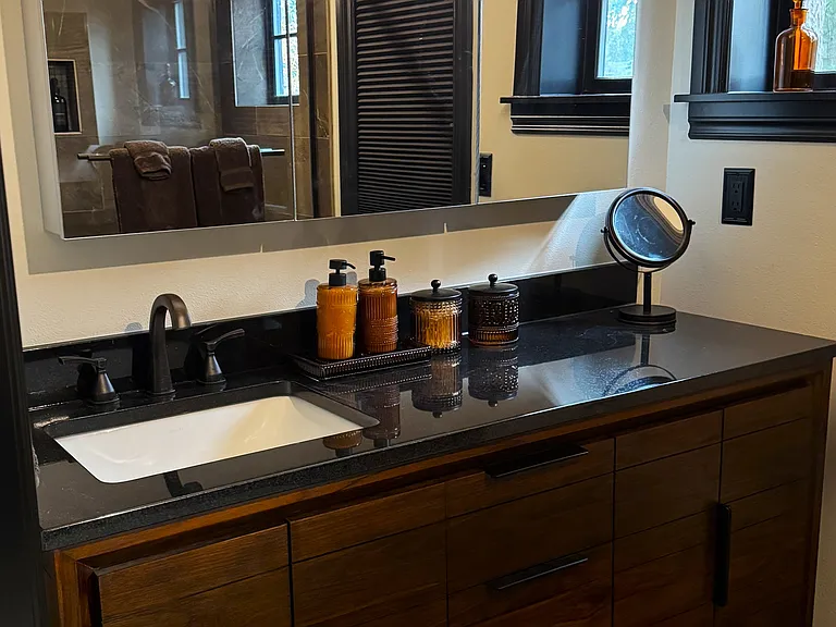 Primary bathroom vanity with upscale finishes and designer mirror/medicine cabinet.