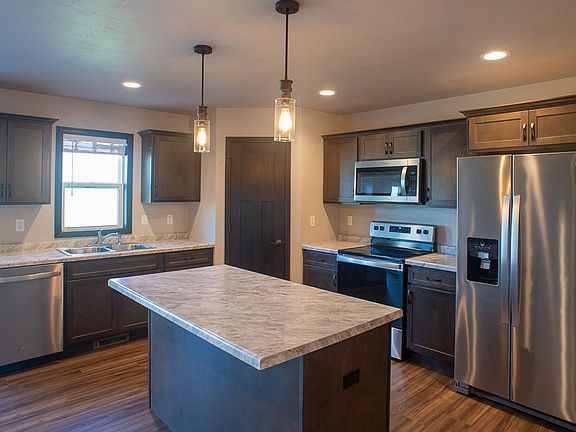 Open kitchen with modern lighting fixtures and appliances.