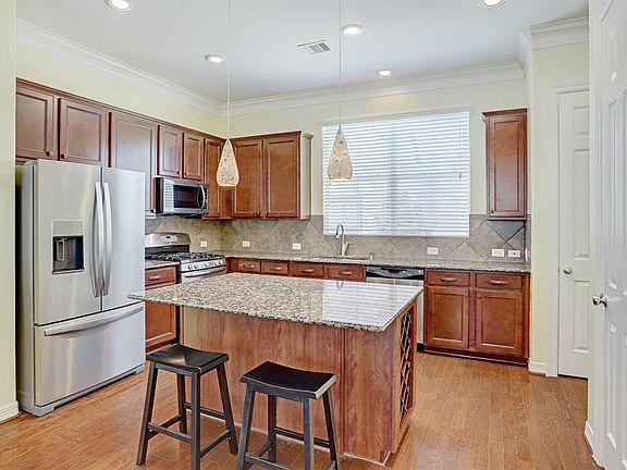The kitchen is centered around a large island, you'll find granite countertops, recessed lighting, and all stainless steel appliances. The refrigerator is included with this home!