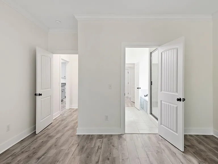 Master bedroom doors leading into common area hallway and master bathroom