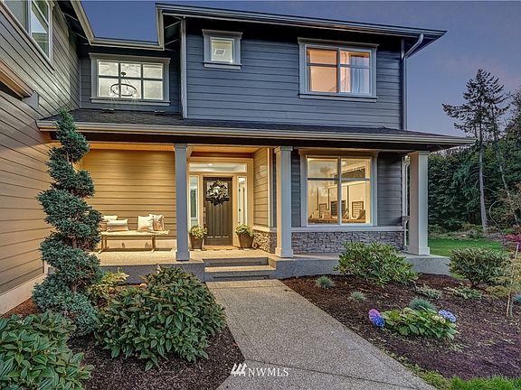 Lighted covered porch entry with cedar planking and enhanced landscaping gives a warm welcome to you and your guests