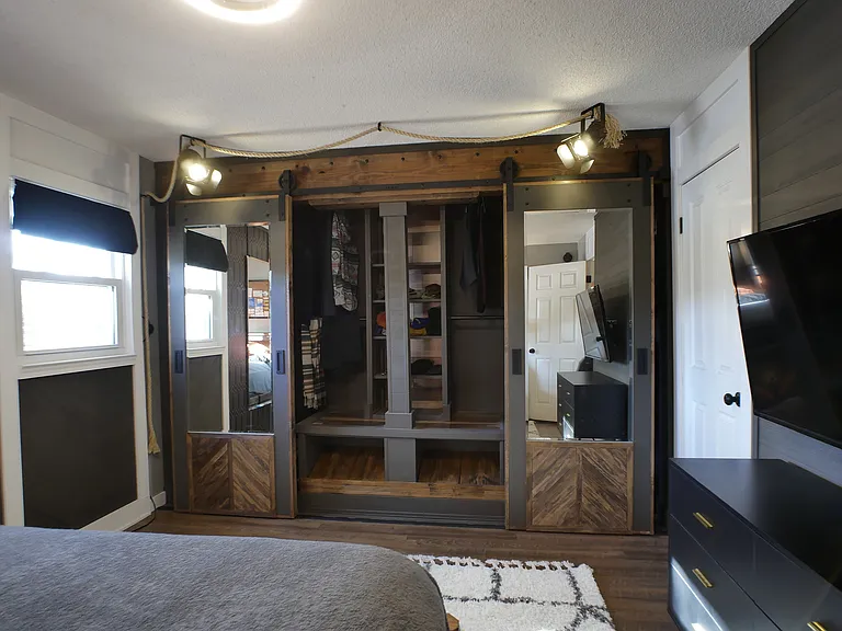 Custom main closet. Features sliding mirror doors, outfit spotlighting, lower shoe rack, center built in shelving, and 4x upper/lower clothing rods.