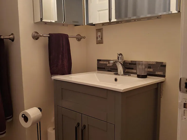 Bathroom sink, lots of storage space in mirrors and cabinet