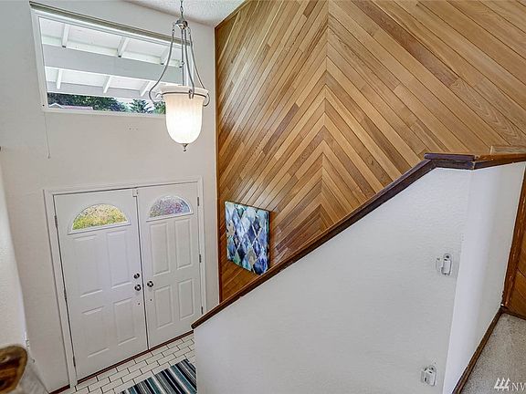 Enter to vaulted ceilings with updated lighting and a warm tongue & groove wood accent wall.