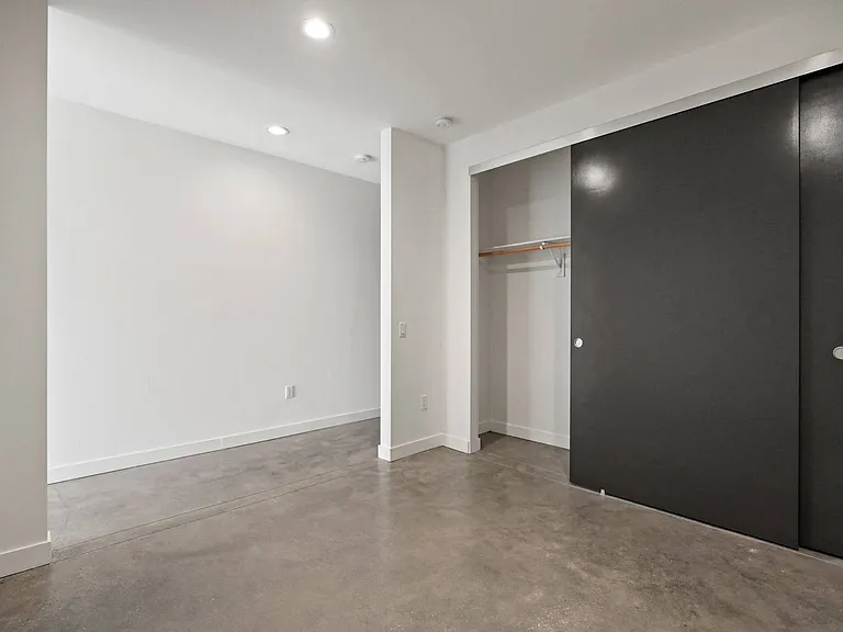 Bedroom with Large Closet and Concrete Flooring