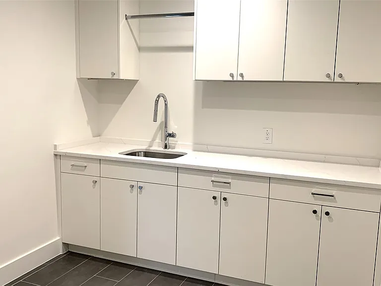Large Laundry Room with lots of cabinets, sink, dripping area and counter space