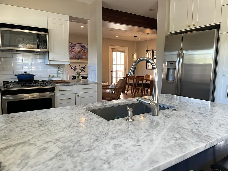 Marble counters, gold pulls and handles to designer finished kitchen.