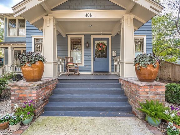 The wide front steps and oversized brick planter benches welcome you into the house.