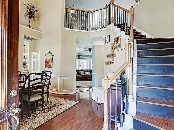 Beautiful grand entrance with a rod iron staircase and wood stairs.