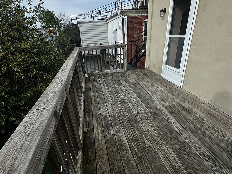 spacious deck overlooking the yard with a fire escape staircase