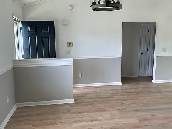 Dining area with new drop light. Looking towards front door, and second and third bedrooms, bathroom, and linen closet