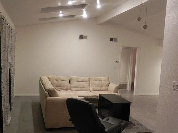 LIVING ROOM - Floor tiles thru-out. Curtains, ceiling fan and skylights installed.