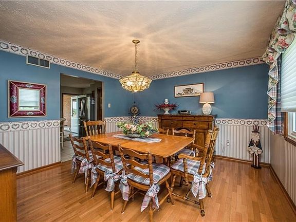 The home's dining room has a wide opening into the updated kitchen as seen center left.  The double windows overlook the front o