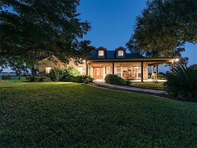 4 sides Masonry with dormer windows and metal roof give this home an unique custom look. Extensive landscaping on flagstone sidewalk leading to front door and mature trees complete this charming picture.