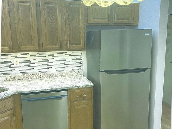 Kitchen with brand new stainless steel appliances, stone and glass tile backsplash and new flooring
