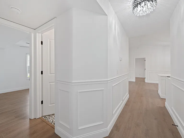 Explore the sophistication of this hallway with its stylish wainscoting and gleaming floors. Explore the sophistication of this hallway with its stylish wainscoting and gleaming floors.