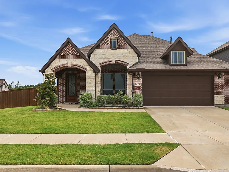 Brick and stone facade residence featuring an attached 2.5-car garage