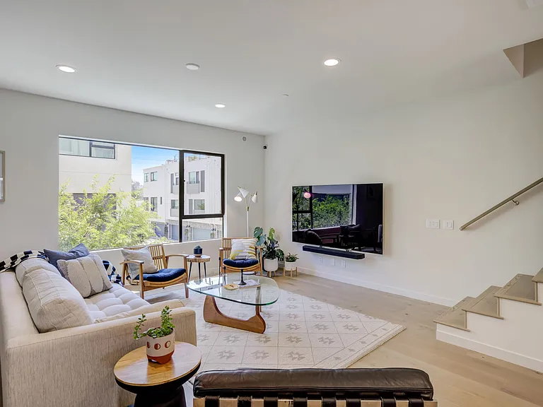 Living area featuring oversized windows that bring in abundant natural light and neighborhood views throughout the day.