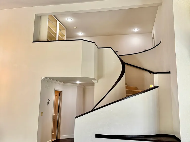 Elegant stairway with wood handrails that complement the hardwood floors