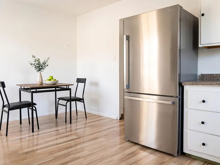 Eat-in kitchen nook with a bistro table, durable flooring, and convenient access to the full-size refrigerator and cabinets.