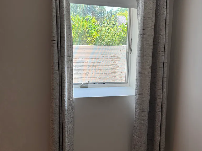 basement view from front of house bedroom with egress window and view of backyard