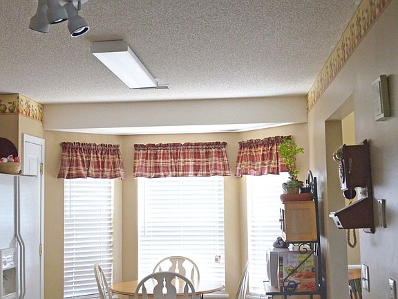 The kitchen has an open window to the living room and bay wi