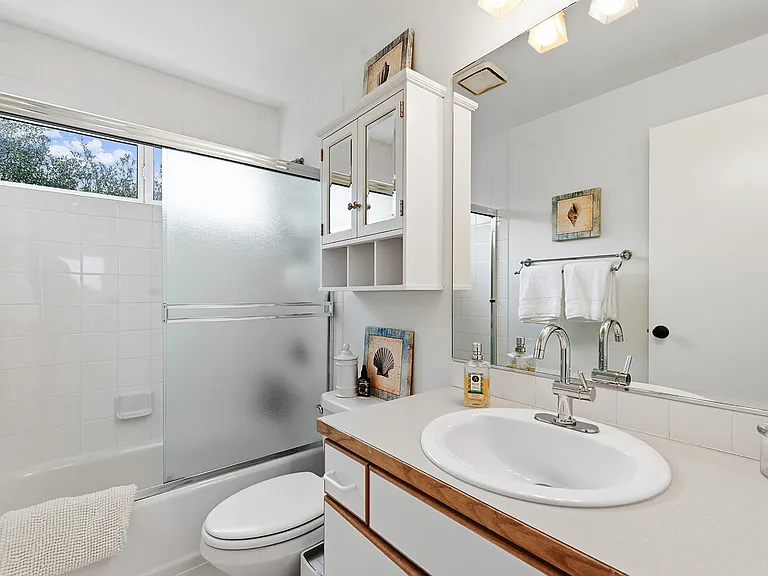 Hall Bath with tub/shower combo, directly adjacent to Bedrooms 2 and 3.