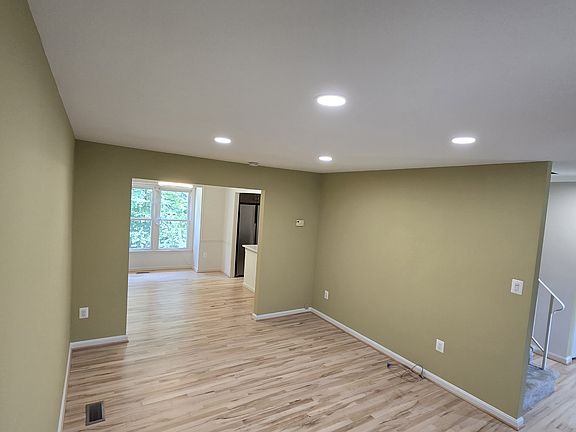 living room new recessed lights, dining at the back, and front door to the right