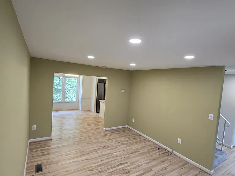 living room new recessed lights, dining at the back, and front door to the right