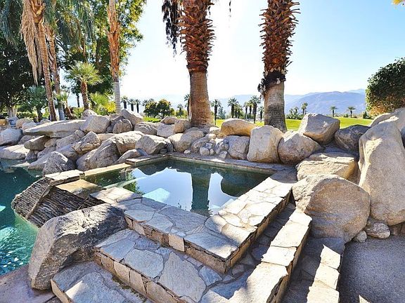 Spa with boulders looking out to mountains.