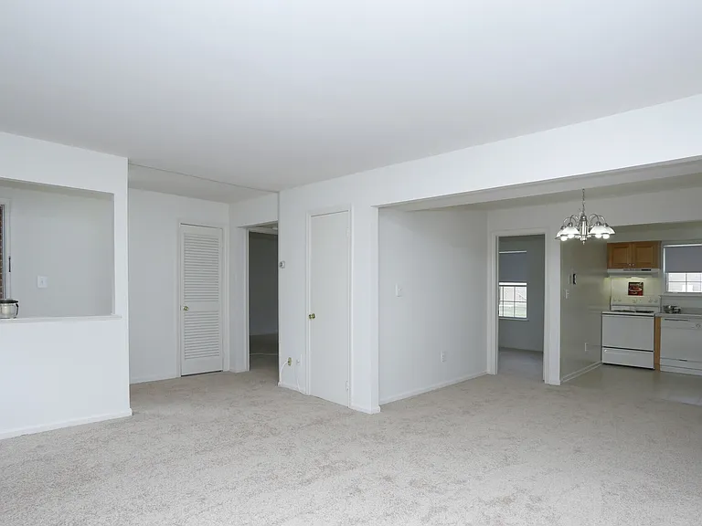 View from Living Room into Dining Room, Kitchen as well as to Bedroom and Entry Area.